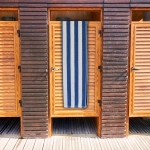 navy striped bath towel with blue and white stripes over wooden door